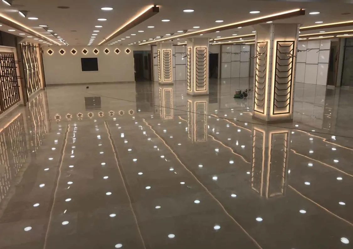 Parlatılmış mermer zeminde tavan ışıklarının yansıdığı salon